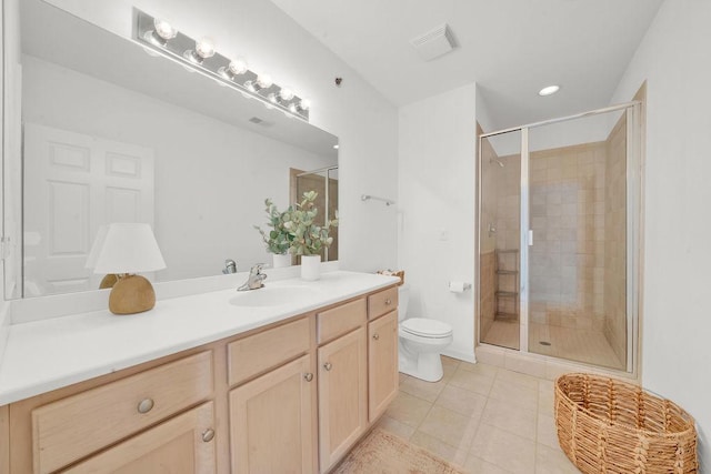 bathroom featuring vanity, tile patterned flooring, a stall shower, and toilet