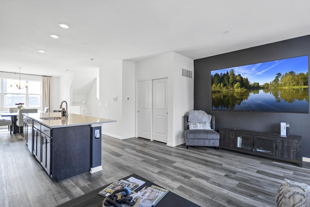 kitchen featuring dark wood-style flooring, a chandelier, light countertops, visible vents, and a sink