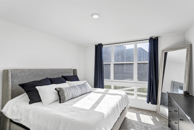 bedroom with light carpet and baseboards