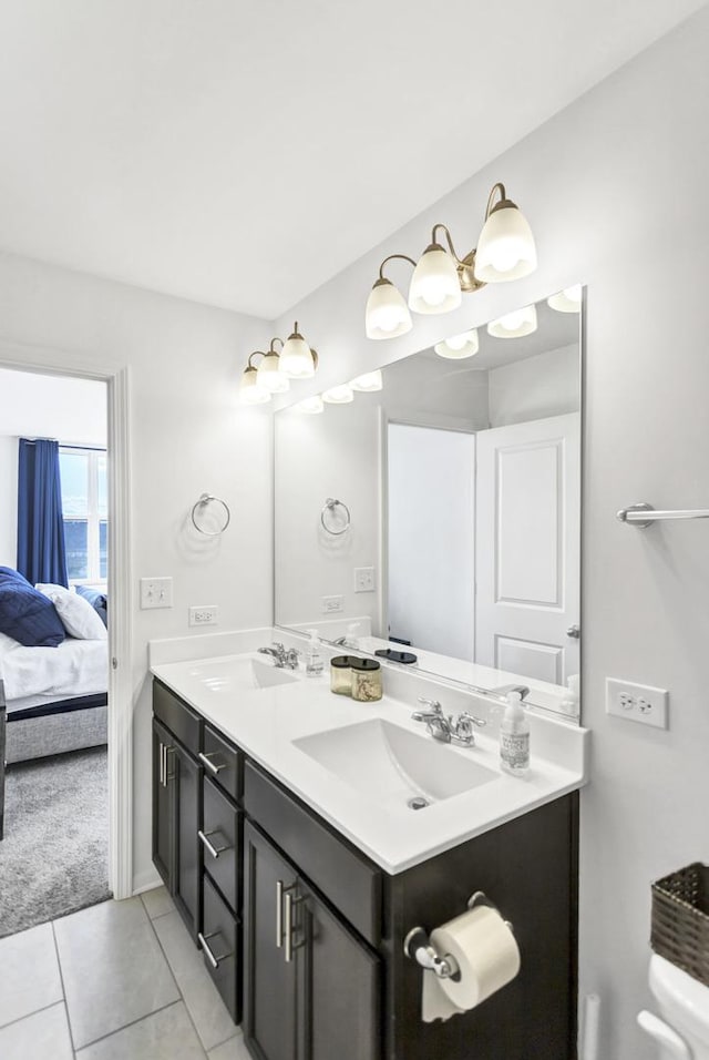full bathroom with a sink, tile patterned floors, double vanity, and ensuite bath