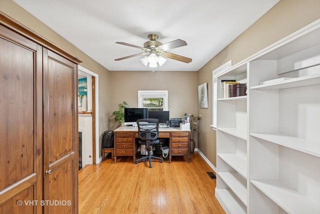 home office with light wood-type flooring, a ceiling fan, and baseboards
