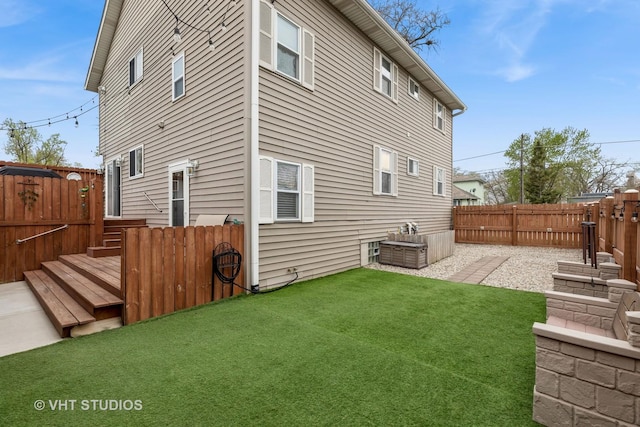 back of property featuring a lawn and a fenced backyard
