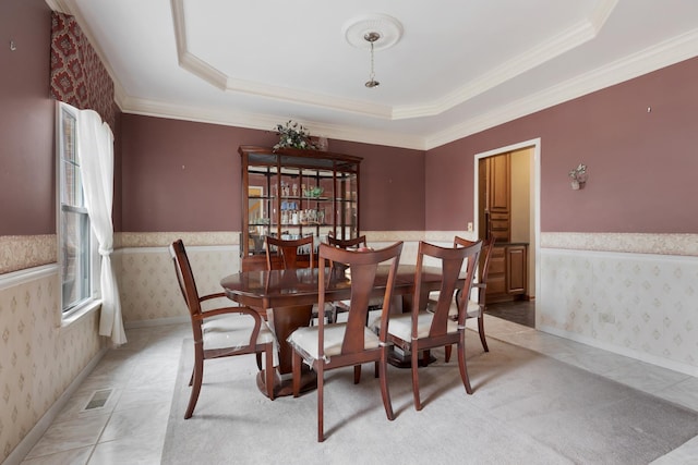 dining area featuring crown molding, visible vents, a tray ceiling, and wallpapered walls