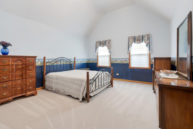 bedroom with carpet, vaulted ceiling, and a wainscoted wall