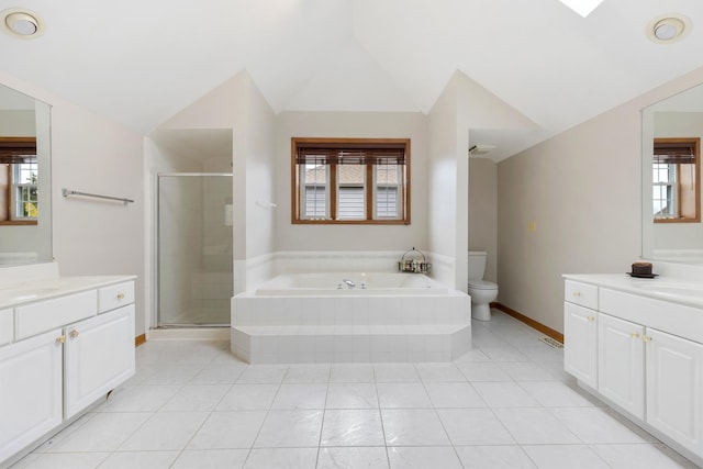 bathroom featuring two vanities, vaulted ceiling, toilet, a shower stall, and a garden tub