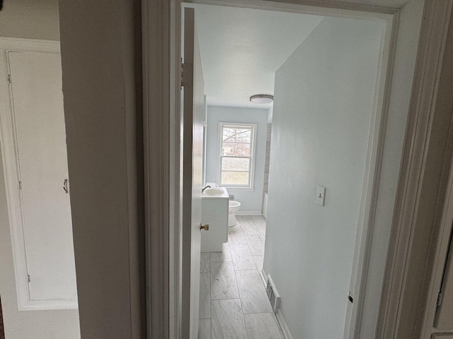 hallway with light wood-style floors and baseboards