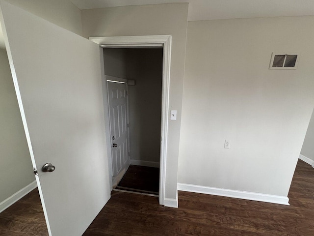 unfurnished room with baseboards and dark wood-style flooring