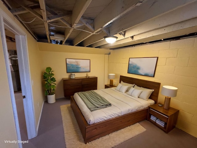 bedroom with concrete block wall and concrete flooring