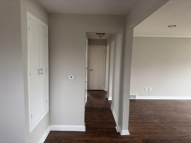 unfurnished living room featuring baseboards, visible vents, and dark wood-type flooring