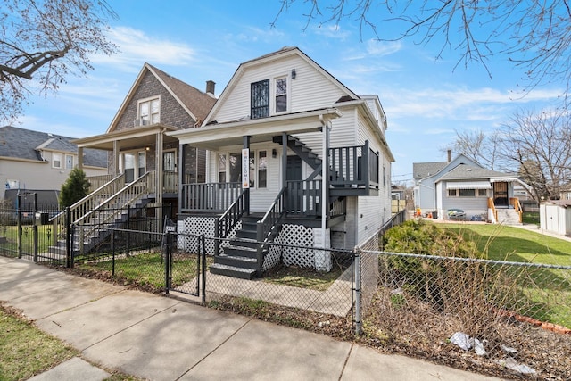 view of front facade with a porch, stairway, a fenced front yard, a gambrel roof, and a gate