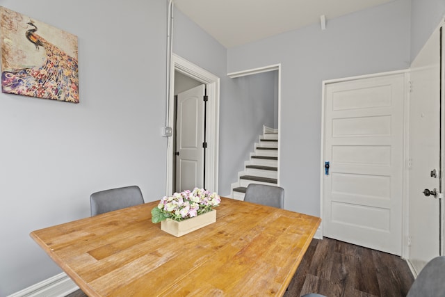 dining room with dark wood-style flooring and stairway