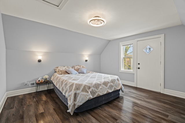 bedroom with baseboards, wood finished floors, and lofted ceiling