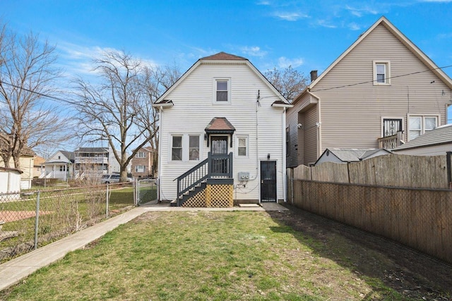 rear view of property with fence, a yard, and a gate