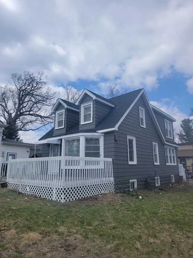 rear view of property with a deck and a lawn