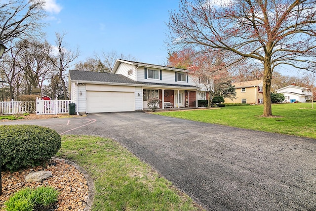traditional home featuring a front lawn, a porch, fence, a garage, and aphalt driveway