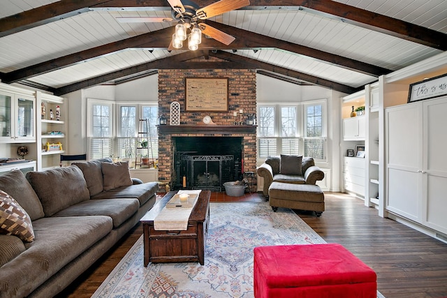 living room with a fireplace, wood finished floors, vaulted ceiling with beams, and plenty of natural light