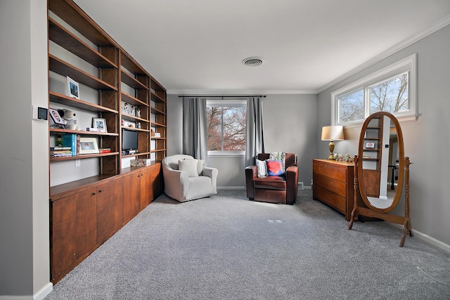 sitting room featuring a wealth of natural light, crown molding, carpet flooring, and visible vents