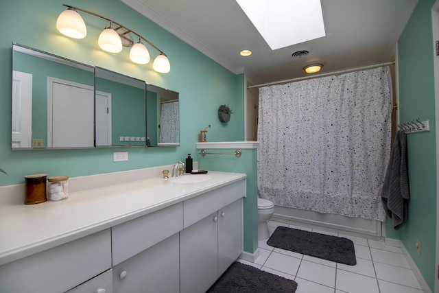 bathroom featuring tile patterned floors, toilet, vanity, crown molding, and a skylight