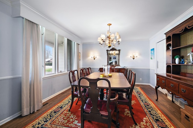 dining space with wood finished floors, crown molding, baseboards, and a notable chandelier