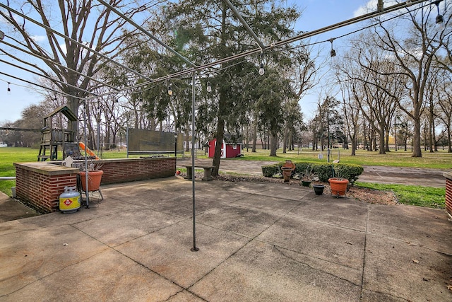 view of home's community with a storage shed, a playground, a trampoline, a lawn, and a patio