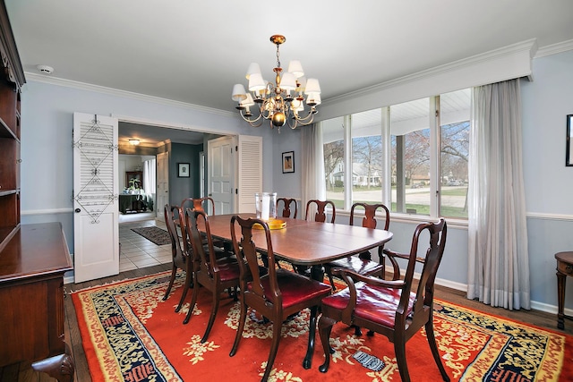 dining area with baseboards, a notable chandelier, wood finished floors, and crown molding