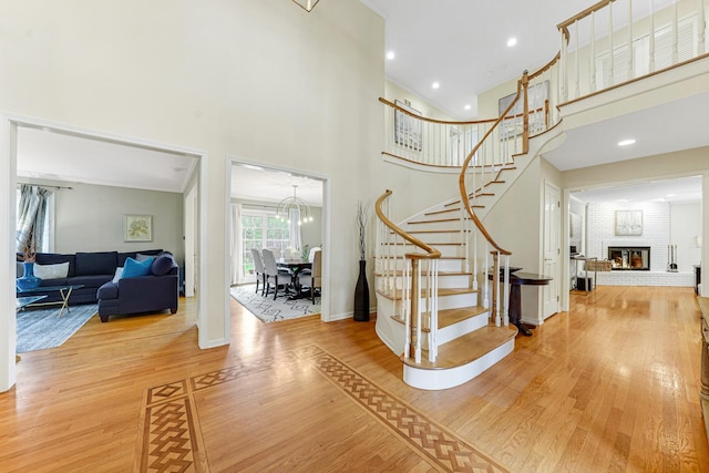 entrance foyer featuring baseboards, stairs, wood finished floors, and a towering ceiling