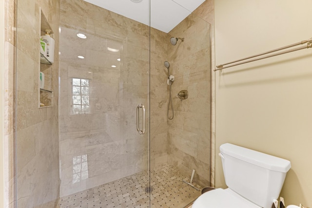 bathroom featuring a shower stall and toilet