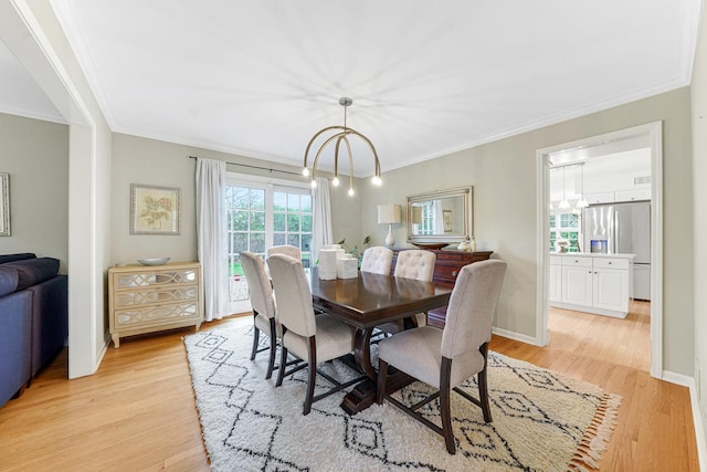 dining area with light wood-type flooring, ornamental molding, and baseboards