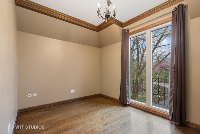 empty room with an inviting chandelier, ornamental molding, plenty of natural light, and wood finished floors