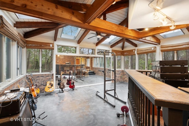 sunroom / solarium featuring lofted ceiling with skylight and finished concrete floors