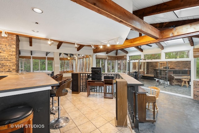 dining area featuring recessed lighting, rail lighting, and lofted ceiling with beams