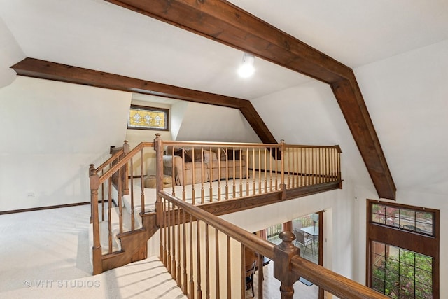 staircase featuring baseboards and vaulted ceiling with beams