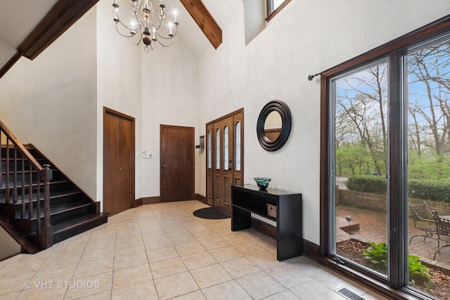 foyer with an inviting chandelier, light tile patterned floors, beam ceiling, and high vaulted ceiling