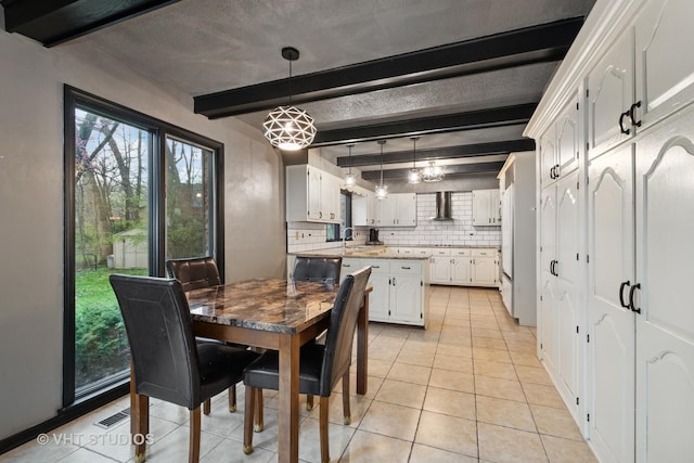 dining area with beamed ceiling, visible vents, and light tile patterned floors