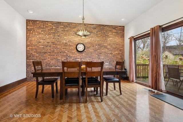 dining room with baseboards and brick wall