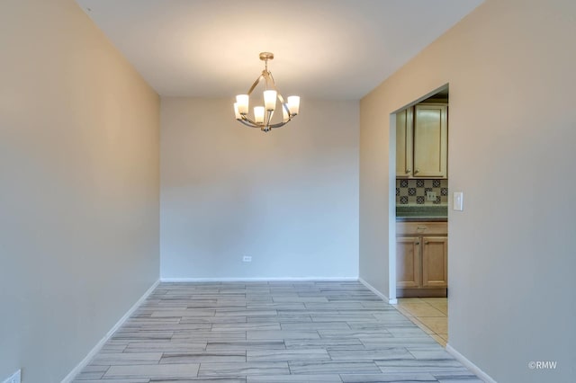 unfurnished dining area featuring baseboards, light wood-type flooring, and a chandelier