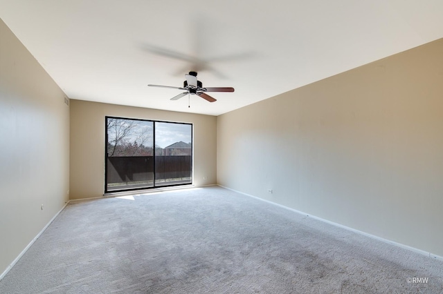 carpeted spare room with baseboards and a ceiling fan