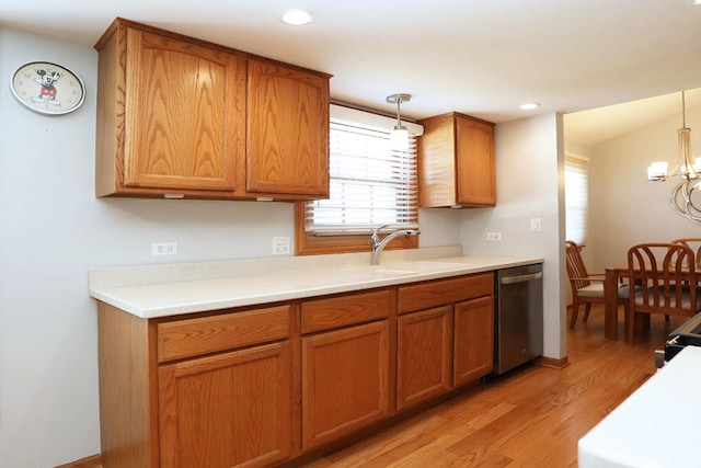 kitchen featuring pendant lighting, stainless steel dishwasher, brown cabinetry, and light wood-type flooring