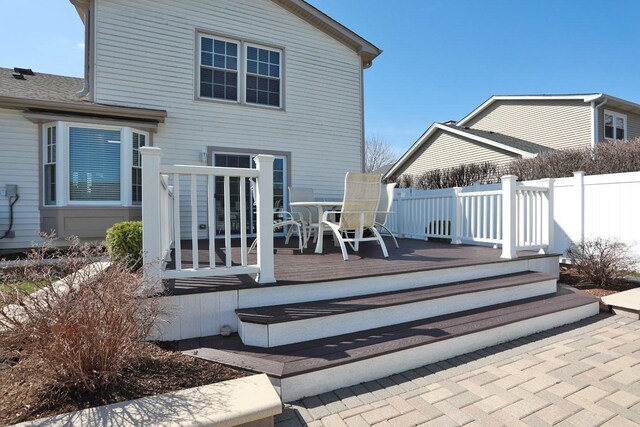 back of house with outdoor dining area, fence, and a deck