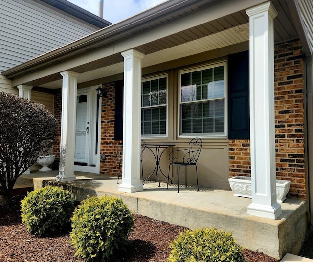 property entrance with brick siding and covered porch