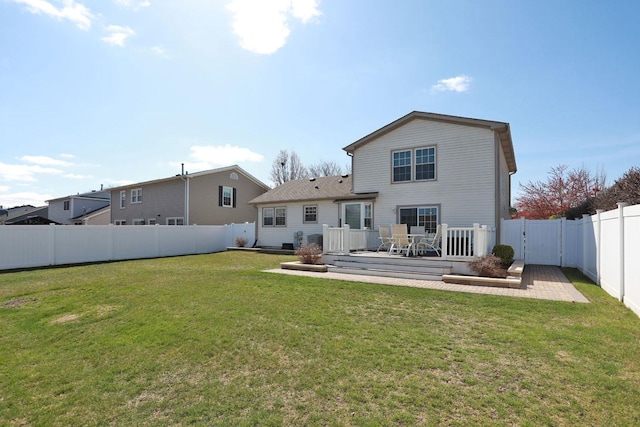 back of house featuring a lawn, a wooden deck, and a fenced backyard