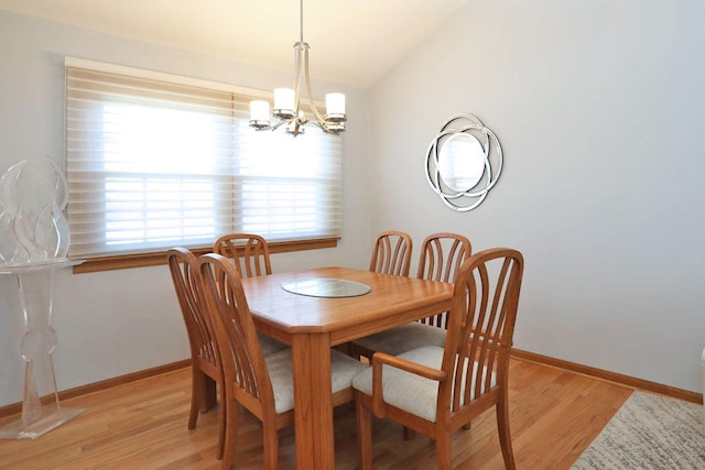 dining room with vaulted ceiling, a chandelier, baseboards, and light wood-style floors