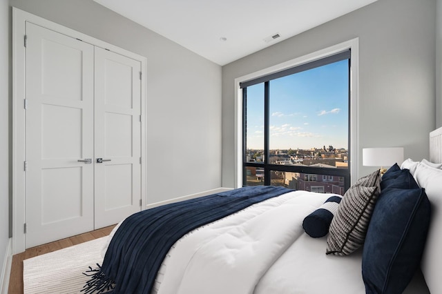 bedroom with visible vents, a closet, and wood finished floors