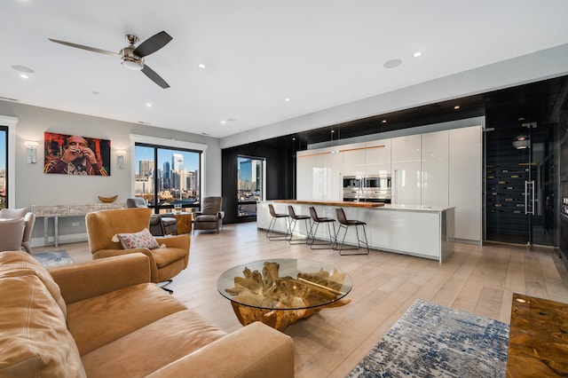 living room featuring light wood finished floors, recessed lighting, and a ceiling fan