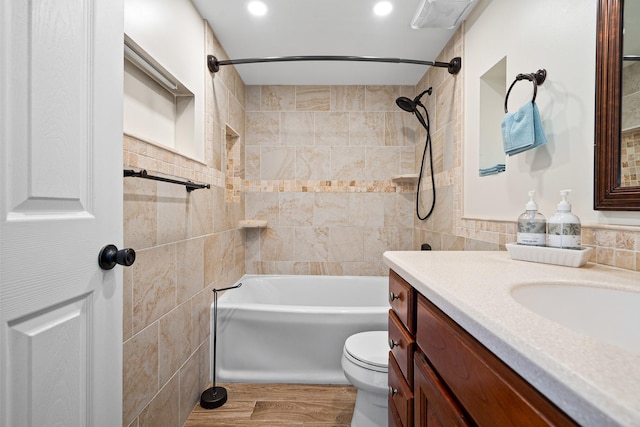 full bathroom with vanity,  shower combination, toilet, tile walls, and wood finished floors