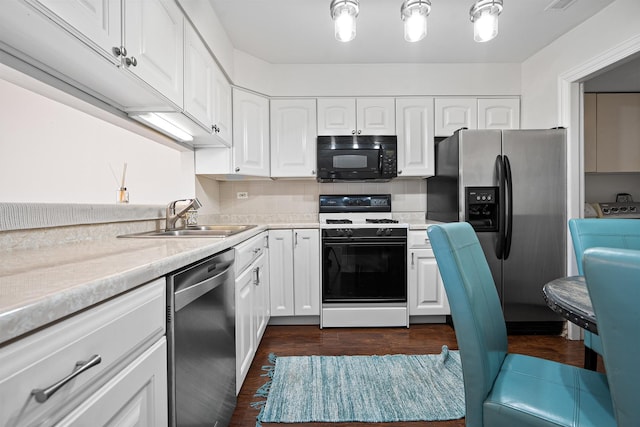 kitchen with stainless steel appliances, light countertops, a sink, and white cabinetry