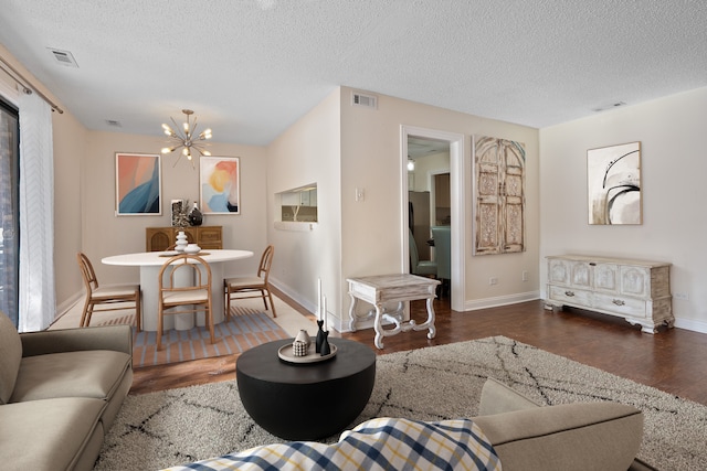 living room with wood finished floors, baseboards, visible vents, and a notable chandelier
