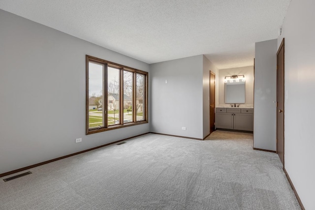 1097 Washington St, Bartlett, IL 60103 - unfurnished bedroom featuring light colored carpet, a textured ceiling, baseboards, and ensuite bath