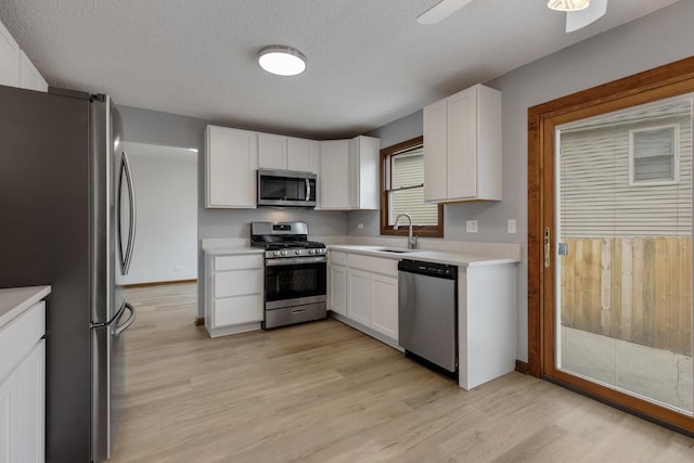 1097 Washington St, Bartlett, IL 60103 - kitchen with stainless steel appliances, light wood finished floors, a sink, light countertops, and white cabinets
