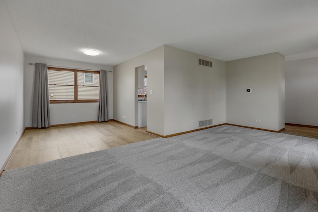 1097 Washington St, Bartlett, IL 60103 - unfurnished room with baseboards, light wood-type flooring, and light carpet